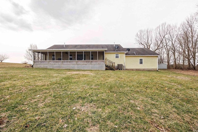 back of property with central AC unit, a lawn, and a sunroom