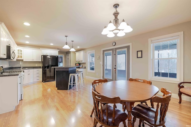 dining room with recessed lighting, light wood-style flooring, baseboards, and french doors