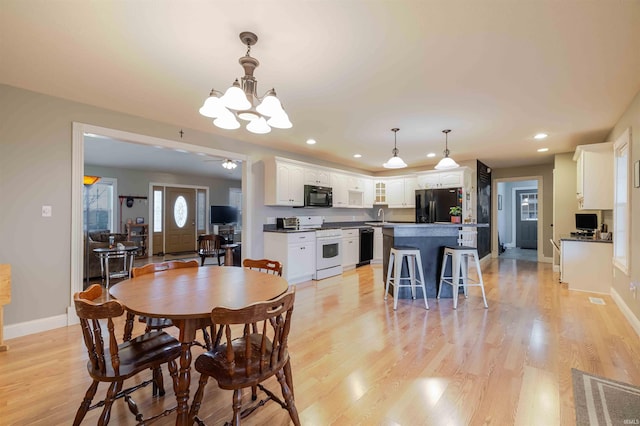 dining room featuring recessed lighting, visible vents, baseboards, light wood-style floors, and ceiling fan with notable chandelier