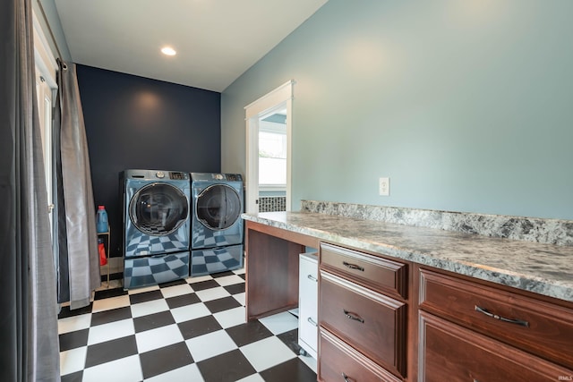 laundry area featuring dark floors, washing machine and clothes dryer, and laundry area