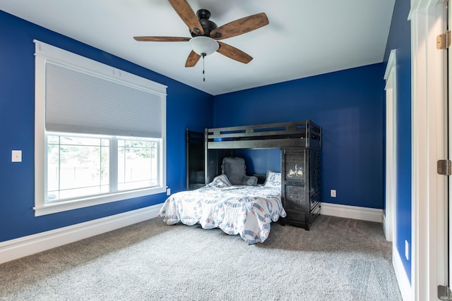 carpeted bedroom with ceiling fan and baseboards