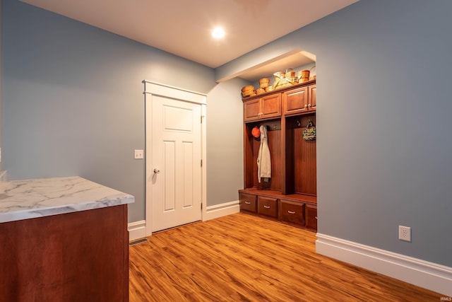 mudroom featuring light wood-type flooring and baseboards