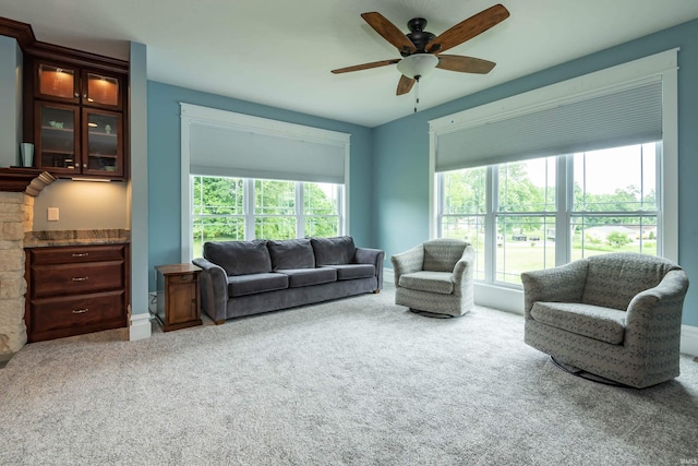 living room with ceiling fan, carpet floors, and a healthy amount of sunlight