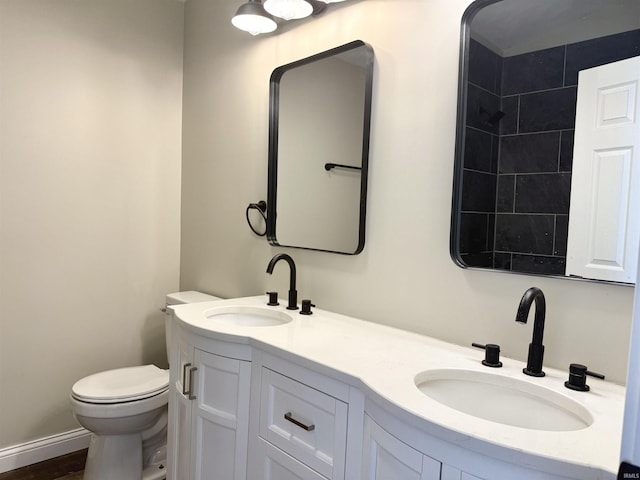 full bathroom with a sink, toilet, and double vanity