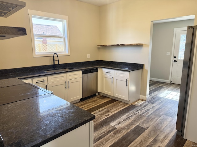 kitchen featuring stainless steel appliances, dark wood-style flooring, a sink, and white cabinets