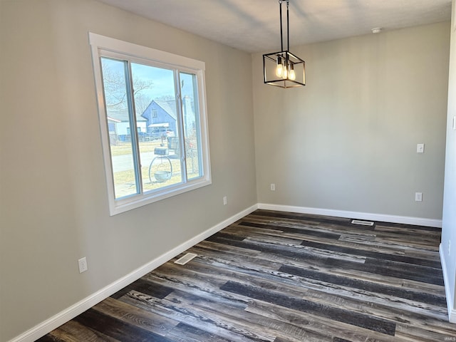 unfurnished dining area featuring visible vents, dark wood finished floors, and baseboards