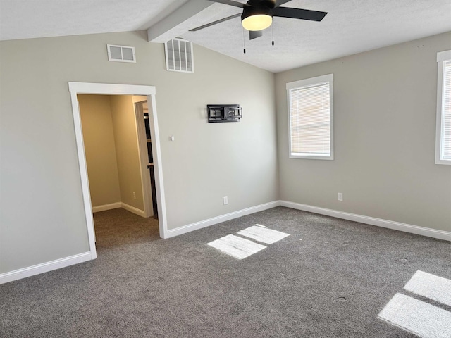 unfurnished room with vaulted ceiling with beams, visible vents, and baseboards