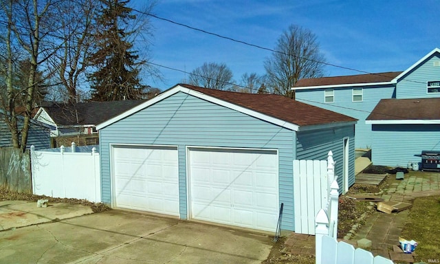 detached garage featuring fence