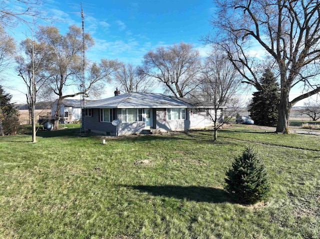 view of front facade with a chimney and a front yard