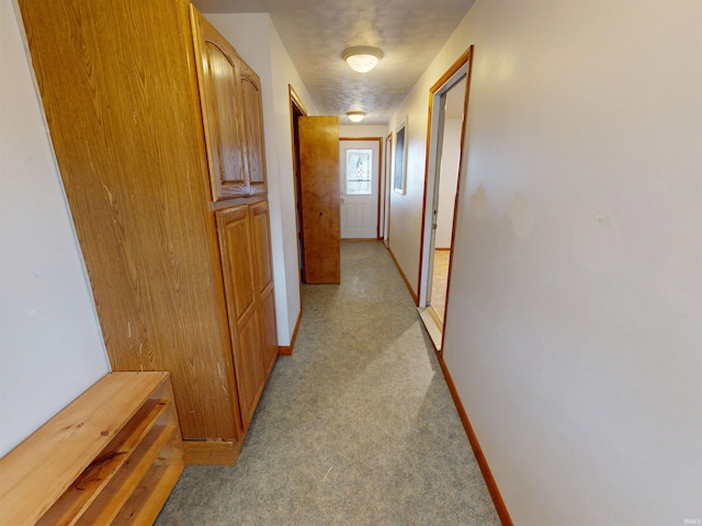 hall with light carpet and baseboards