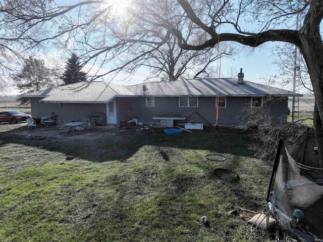 back of property featuring a patio, a lawn, and a chimney