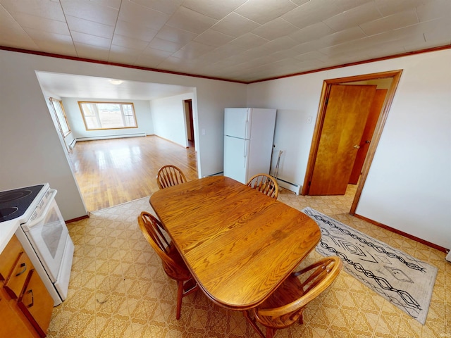 dining area featuring a baseboard radiator, baseboards, baseboard heating, and crown molding