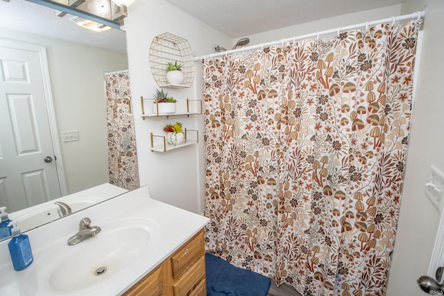 bathroom with a shower with shower curtain, a textured ceiling, and vanity