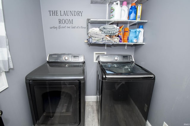 laundry area with wood finished floors, laundry area, baseboards, and separate washer and dryer