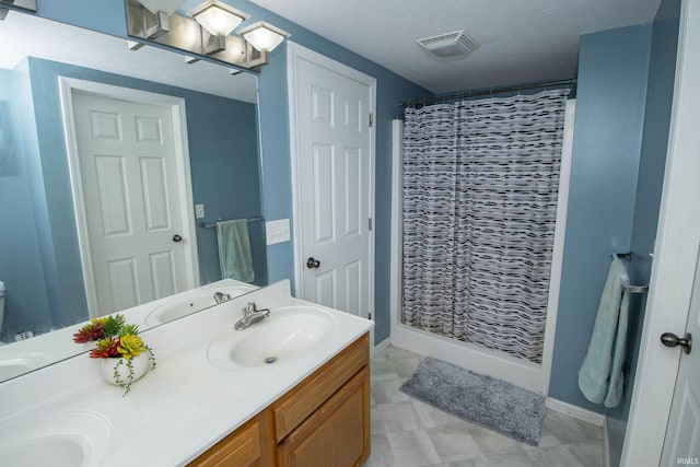 bathroom featuring double vanity, a shower with shower curtain, a sink, and visible vents