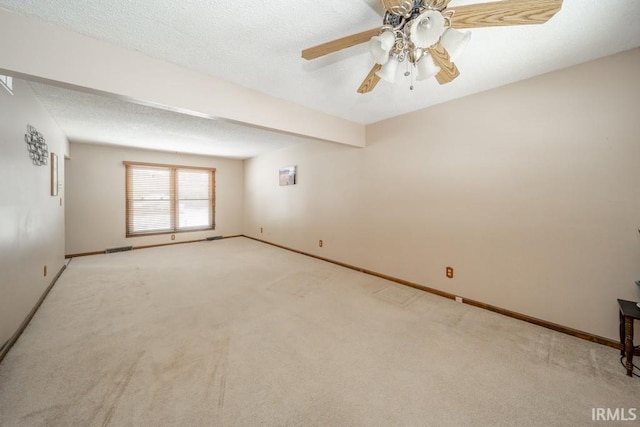 spare room with carpet floors, a textured ceiling, and baseboards