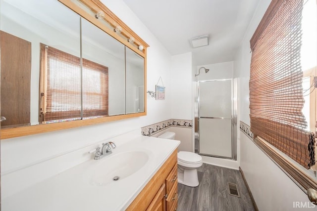 full bathroom with toilet, vanity, wood finished floors, and a shower with shower door