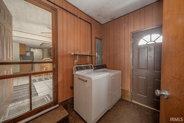 washroom with laundry area, electric panel, separate washer and dryer, and wood walls