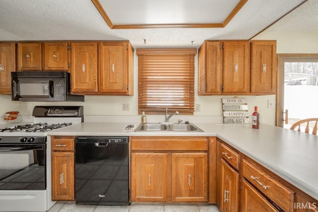 kitchen with light countertops, a sink, a textured ceiling, and black appliances