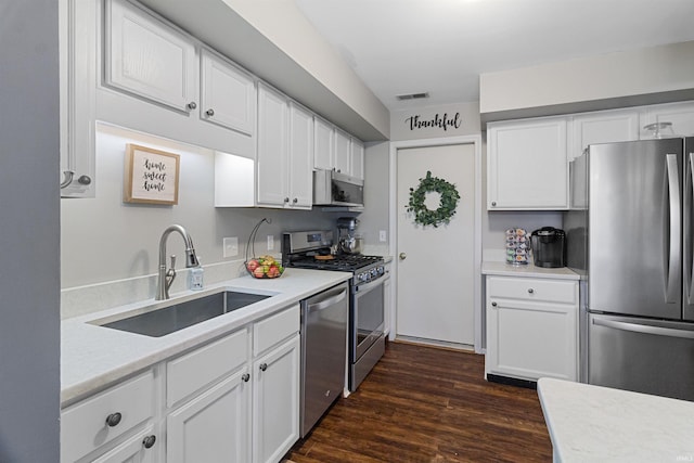 kitchen featuring a sink, visible vents, white cabinetry, appliances with stainless steel finishes, and dark wood-style floors