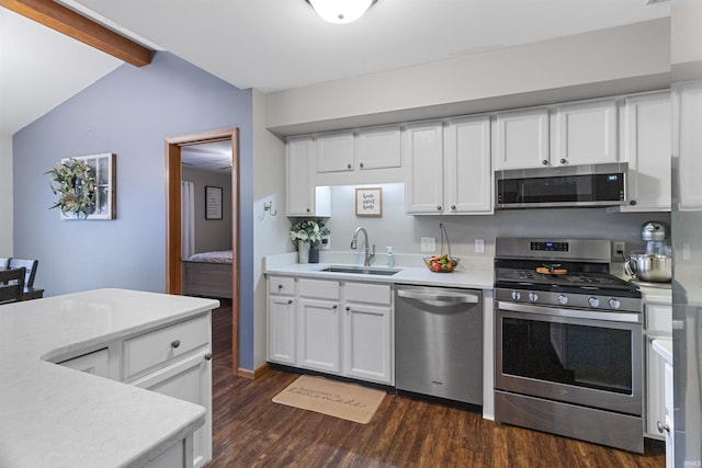 kitchen featuring stainless steel appliances, a sink, white cabinets, light countertops, and dark wood-style floors