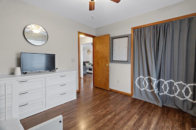 bedroom with dark wood-type flooring, ceiling fan, and baseboards