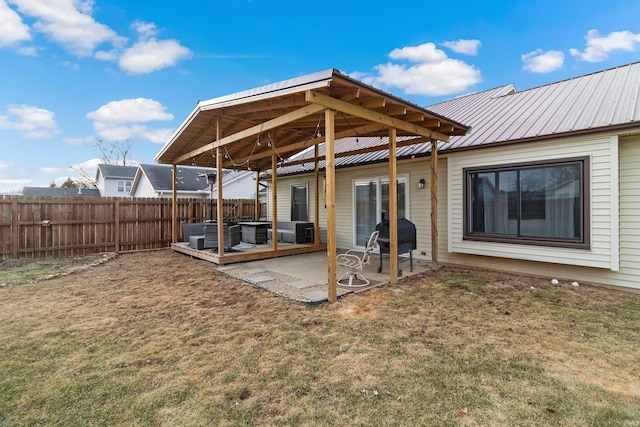 rear view of house featuring a patio area, fence, metal roof, and a yard