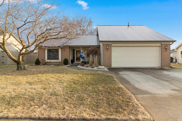 ranch-style home featuring brick siding, a front yard, metal roof, a garage, and driveway