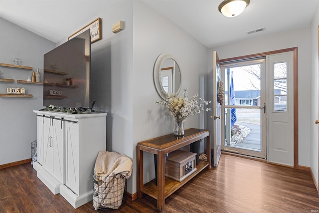 foyer featuring dark wood-style flooring, visible vents, and baseboards