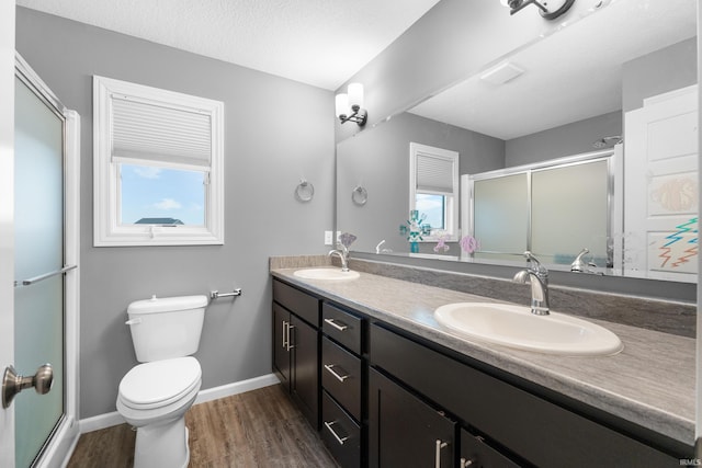 full bathroom with a stall shower, a sink, and wood finished floors