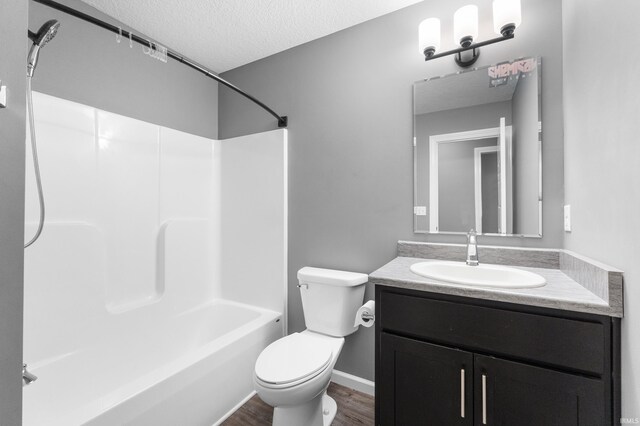 bathroom with shower / bathtub combination, toilet, vanity, a textured ceiling, and wood finished floors