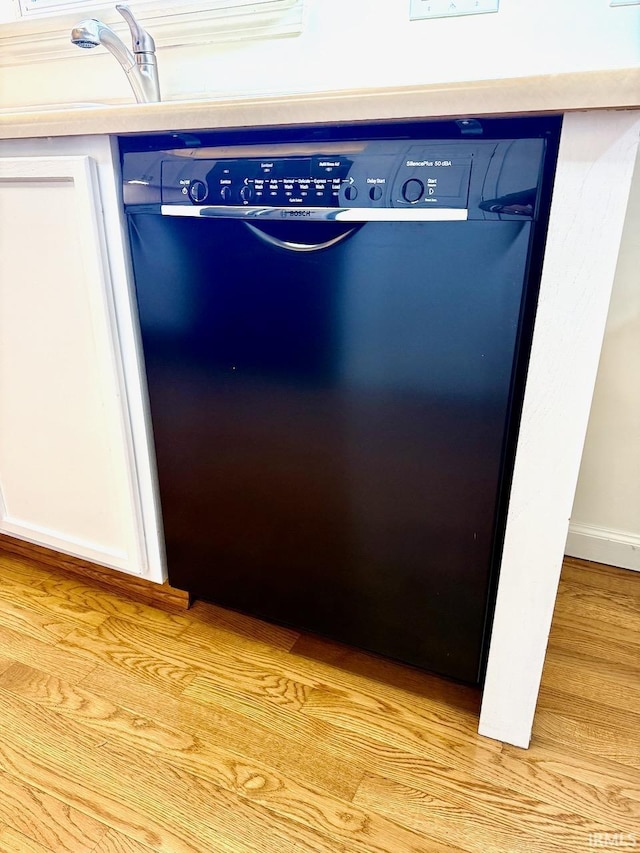 interior details featuring blue cabinets, light wood-type flooring, dishwasher, and baseboards