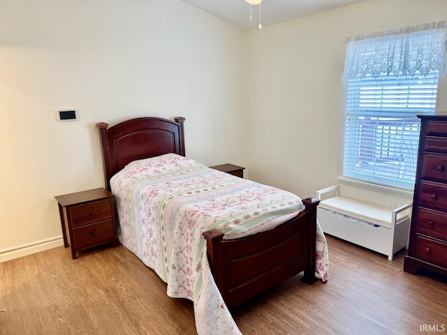 bedroom featuring wood finished floors and baseboards