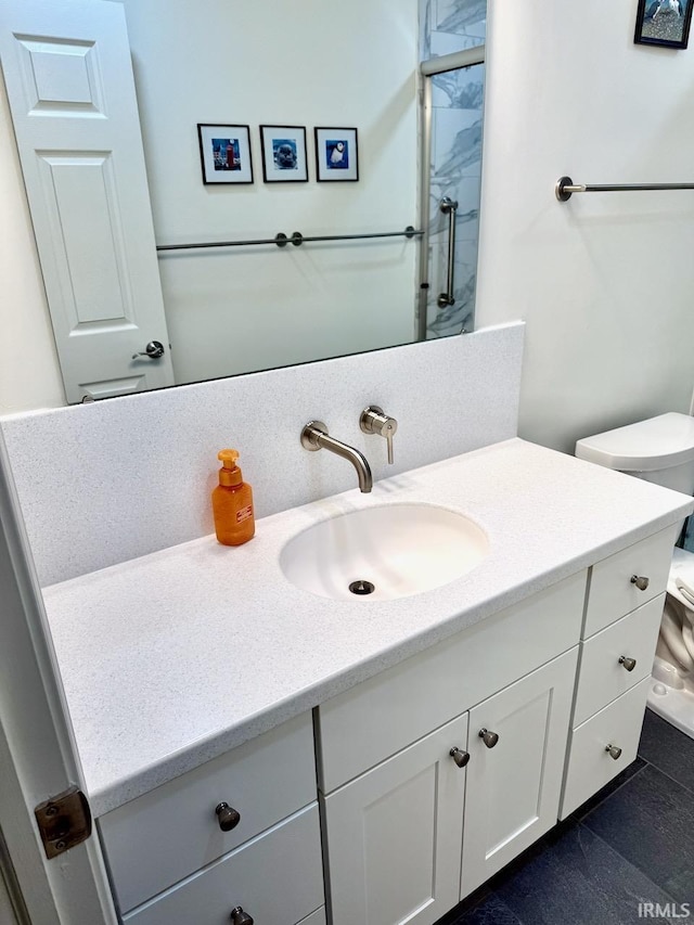 bathroom featuring toilet, walk in shower, and vanity