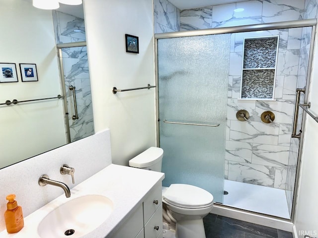 bathroom featuring toilet, vanity, and a marble finish shower