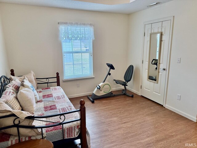 bedroom with light wood-style flooring, visible vents, and baseboards