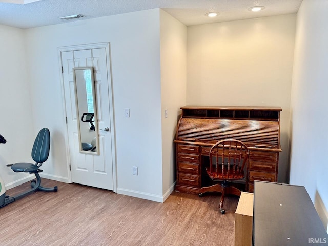 office space with a textured ceiling, recessed lighting, wood finished floors, visible vents, and baseboards