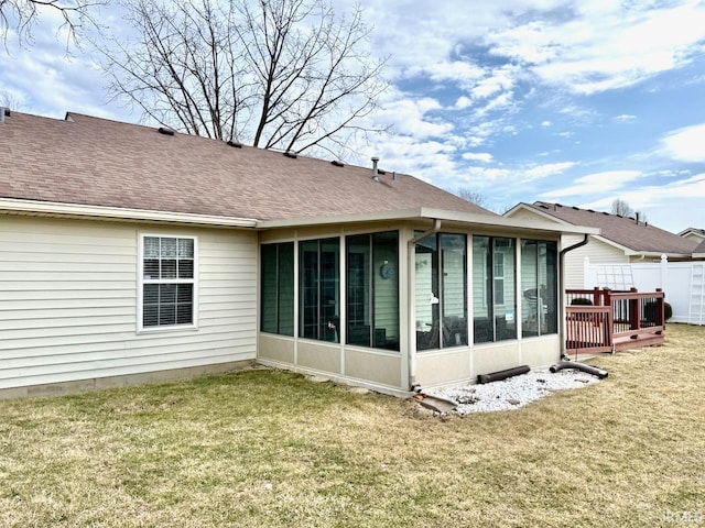 rear view of property with a shingled roof, a lawn, fence, and a sunroom