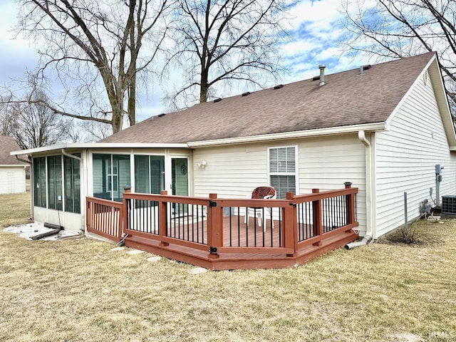 rear view of property with a sunroom, a shingled roof, a deck, and a yard