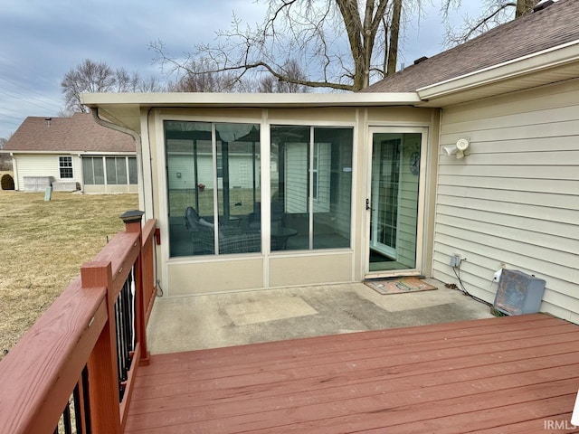 deck with a sunroom and a lawn