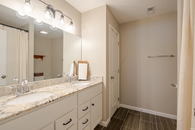 full bathroom with visible vents, a sink, baseboards, and double vanity