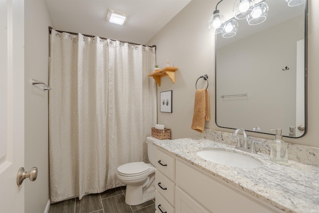 bathroom featuring toilet, curtained shower, and vanity