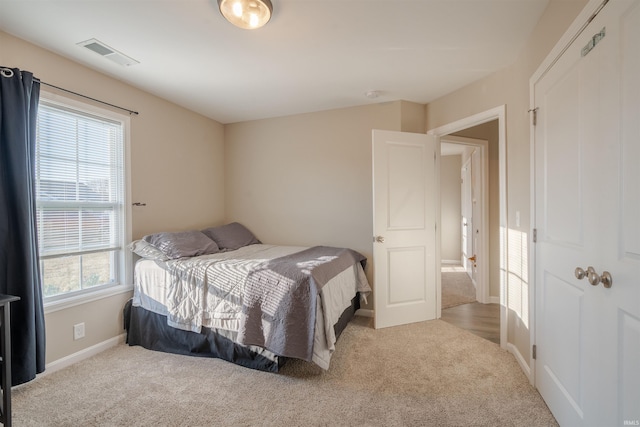 carpeted bedroom with baseboards and visible vents