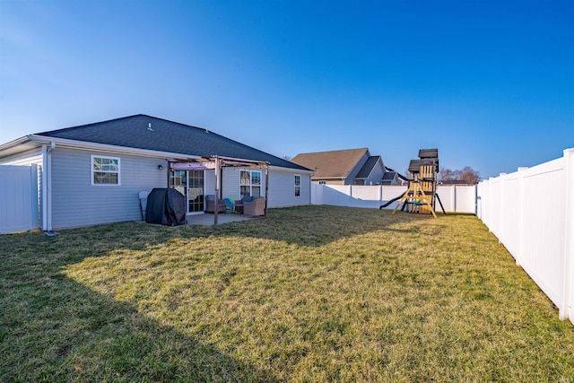 back of house with a yard, a patio, a playground, and a fenced backyard