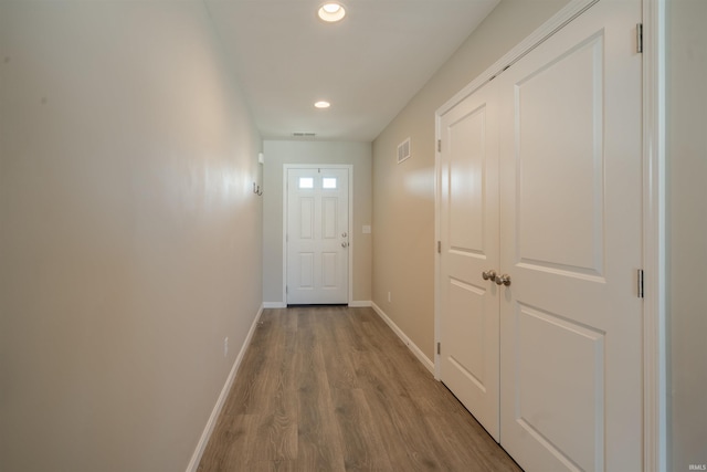 doorway to outside featuring visible vents, baseboards, wood finished floors, and recessed lighting