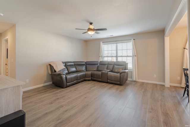 living room with a ceiling fan, light wood-type flooring, visible vents, and baseboards