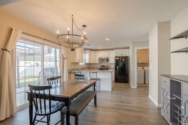 dining space featuring recessed lighting, an inviting chandelier, washing machine and dryer, light wood-type flooring, and baseboards