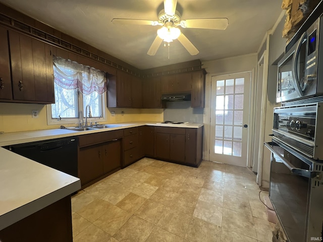 kitchen featuring light countertops, a sink, dark brown cabinets, black appliances, and exhaust hood