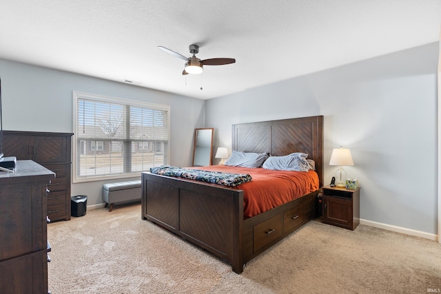 bedroom with baseboards, a ceiling fan, visible vents, and light colored carpet