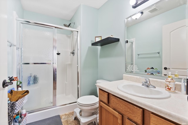 full bathroom featuring a shower stall, toilet, and vanity